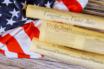 Founding documents of United States displayed on an American flag, illustrating key principles...