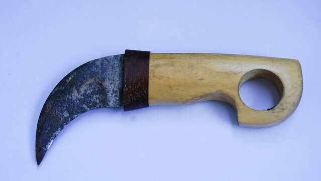 Traditional karambit knife with rusty blade and wooden handle