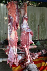A close-up view of freshly slaughtered cow carcasses hanging on metal hooks during the week of Eid al-Adha, also known as Hari Raya Haji, a significant Islamic festival in Malaysia.