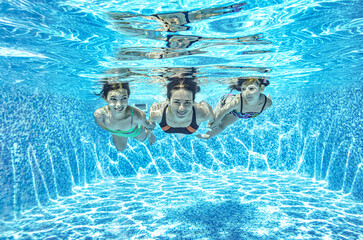 Family swims underwater in swimming pool, happy active mother and children have fun under water, fitness and sport with kids on summer holiday vacation