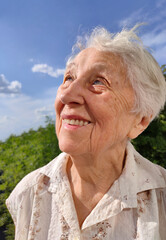 Positive senior woman watering decorative plants on balcony