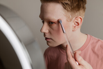 A Close-up of A Young Man Applying Eyeshadow in Front of Mirror
Medium shot of a young man applying...