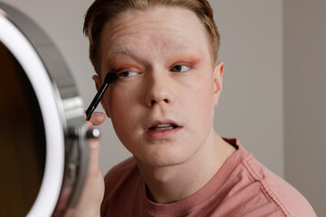 A Close-up of A Young Man Applying Eyeshadow in Front of Mirror
Medium shot of a young man applying...