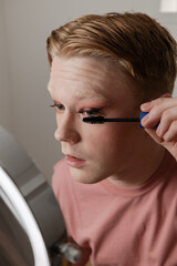Young Man Applying Mascara Makeup Routine Beauty Vertical Closeup
A young man applies mascara while...