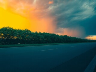 Dramatic sunset sky over highway roadside trees