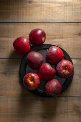 Some vibrant red apples rest on a rustic wooden background, highlighting their fresh appeal. Perfect for themes related to healthy eating, natural food, or autumn harvest.