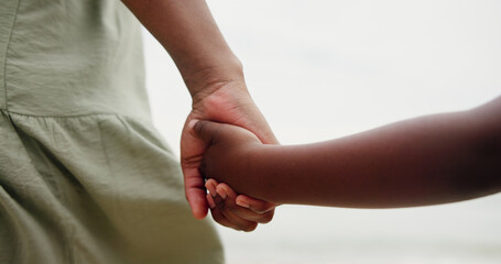 Holding hands, parent and child at beach on vacation with care, love and bonding in nature. People,...