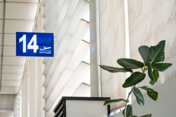 Blue information board showing travelers the way to the boarding gates at daytime inside the...
