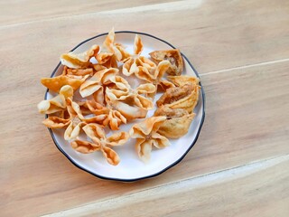 batagor, made from fish or chicken dumplings, tofu filled with tapioca flour served with peanut sauce, soy sauce and chili sauce. popular indonesian snack.