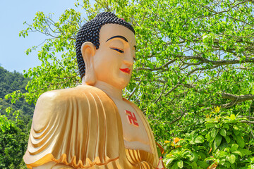 Gilded statue of Buddha on blue sky background
