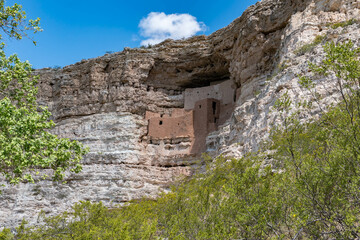 Ancient cliff dwellings built into limestone cliffs in Arizona. Stunning red rock architecture, scenic canyon views, and historic cultural heritage captured in clear desert light