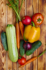 Fresh vegetables arranged on a wooden surface showcasing colorful produce in natural sunlight
