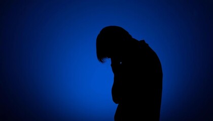 Silhouette of a bowed head against a somber, dark blue background with falling, translucent teardrop shapes,  somber,  sorrow