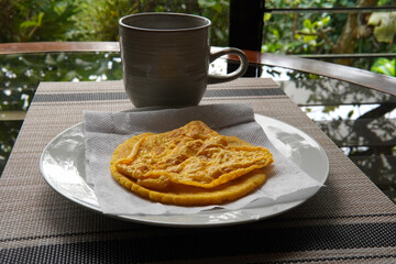Typical Costa Rican breakfast: tortilla with egg and a glass of coffee or torta de huevo con tortilla
