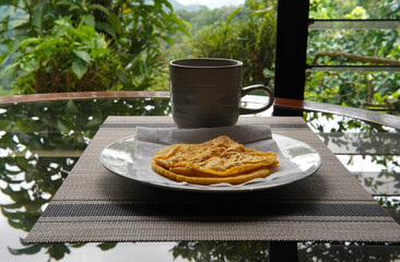 Typical Costa Rican breakfast: tortilla with egg and a glass of coffee or torta de huevo con tortilla