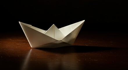 Obraz premium Paper Boat: A Minimalist Origami Creation in Dramatic Light
