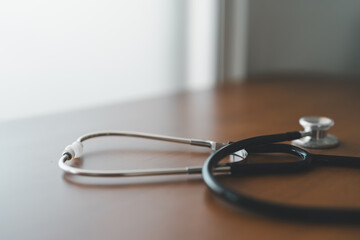Stethoscope on wooden surface with gentle lighting, reflecting calm and focused medical practice, healthcare tools, and the role of basic instruments in professional treatment environments.