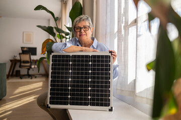 Woman indoors with solar panel promoting green energy