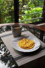 Typical Costa Rican breakfast: tortilla with egg and a glass of coffee or torta de huevo con tortilla