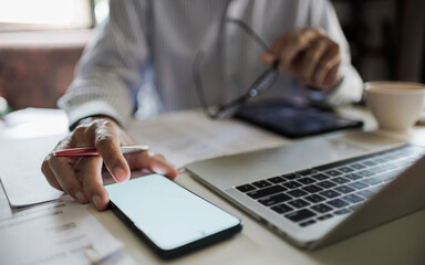 asian businessman working in office using mobile phone and laptop meeting online with business group to make business plan