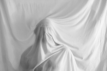silhouette of a person against the background of a white sheet, the effect of a statue or a ghost