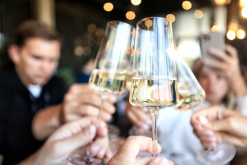 Friends with glasses of wine clink glasses holiday, a group of people abstract blurred background