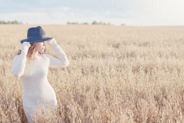 Summer Look female model posing in a field against the sky, the concept of natural freedom and femininity