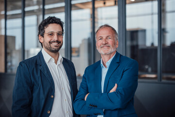 Two engineers in business attire smiling confidently in an office setting
