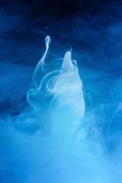 Abstract image of liquid ink creating dynamic tornado shapes in water