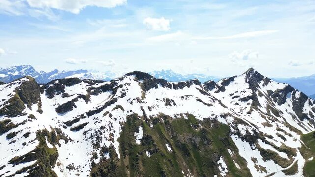 Aerial: snowy mountain peak and Dents du Midi mountain range in the back during the day above Lake Lioson, in the canton of Vaud, Switzerland, crane up drone shot