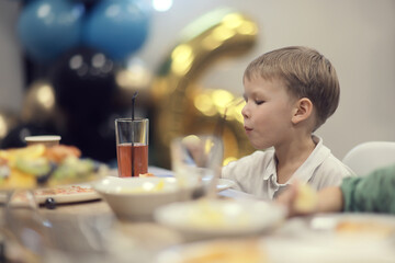 6 years old boy at a birthday party, celebration at a cafe dinner