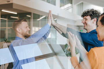 Businesspeople celebrating success with a high five in an office setting