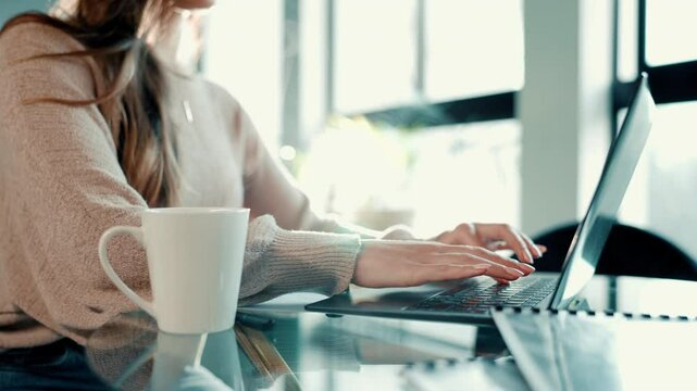 Hands, laptop and typing with coffee for remote work at home for information, research and writing. Woman, tea and technology with book author for freelancing and publishing content online on website
