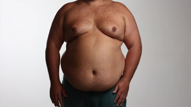 Overweight man shrugs against white background, weight loss goals