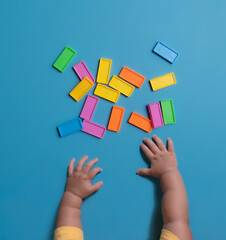 The child plays with colorful blocks. Family vacation with children for the holidays,top view