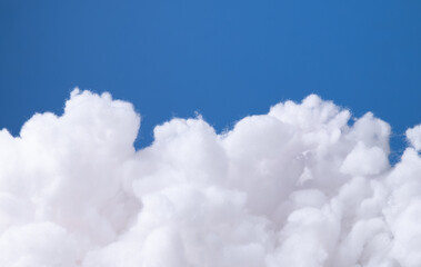Siliconized hollowfiber, polyester fiber cloud held against a blue background