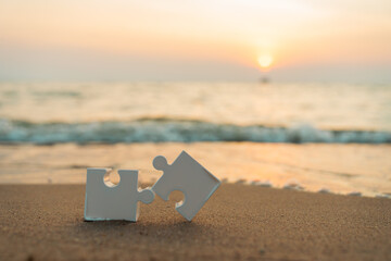 Business thinking and problem solving concepts, white jigsaw puzzle on sand.