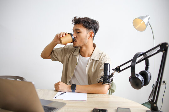 Online Podcaster Man Drinking Coffee During Live Podcast in Recording Studio
