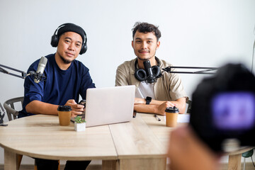 Podcast Session in Progress with Two Men Talking and Camera Rolling