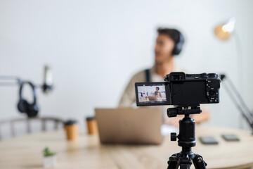 Man Hosting Podcast While Being Filmed by DSLR Camera in Studio.