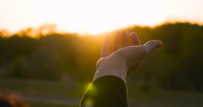Open hand in golden sunset close-up. palm at sunset human connection with nature. peace and harmony through open hand energy of the surrounding world