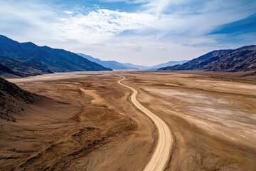 Aerial view of an expansive desert plain with a single dirt road cutting through the landscape