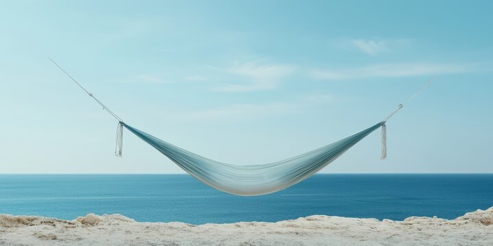 relax hammock beach concept. A serene hammock suspended over a tranquil ocean view under a clear blue sky.