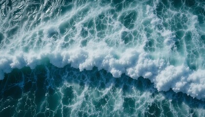 Fototapeta premium Aerial view of turbulent ocean waves with frothy white foam under natural daylight