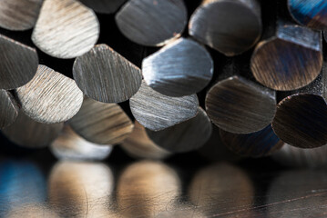 Close-up of cut non-ferrous metal rods stacked together, showing texture and reflections, industrial macro detail