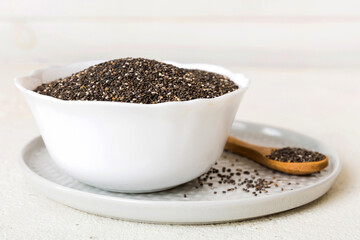 Chia seeds in bowl and spoon on colored background. Healthy Salvia hispanica in small bowl. Healthy superfood
