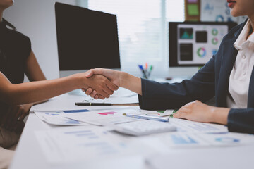 Businesswomen shaking hands after successful meeting in office