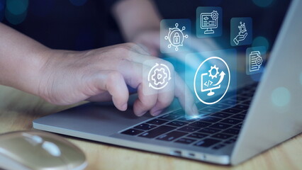 Engineer using laptop computer to optimize and improve systems.Coding and development automation. Automated maintenance and system updates.