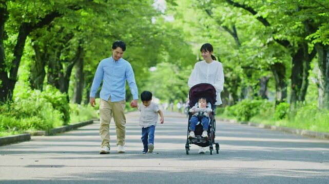 新緑の公園を散歩する家族
