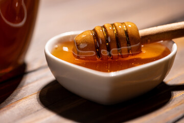 Fresh floral honey in a heart-shaped bowl, close-up